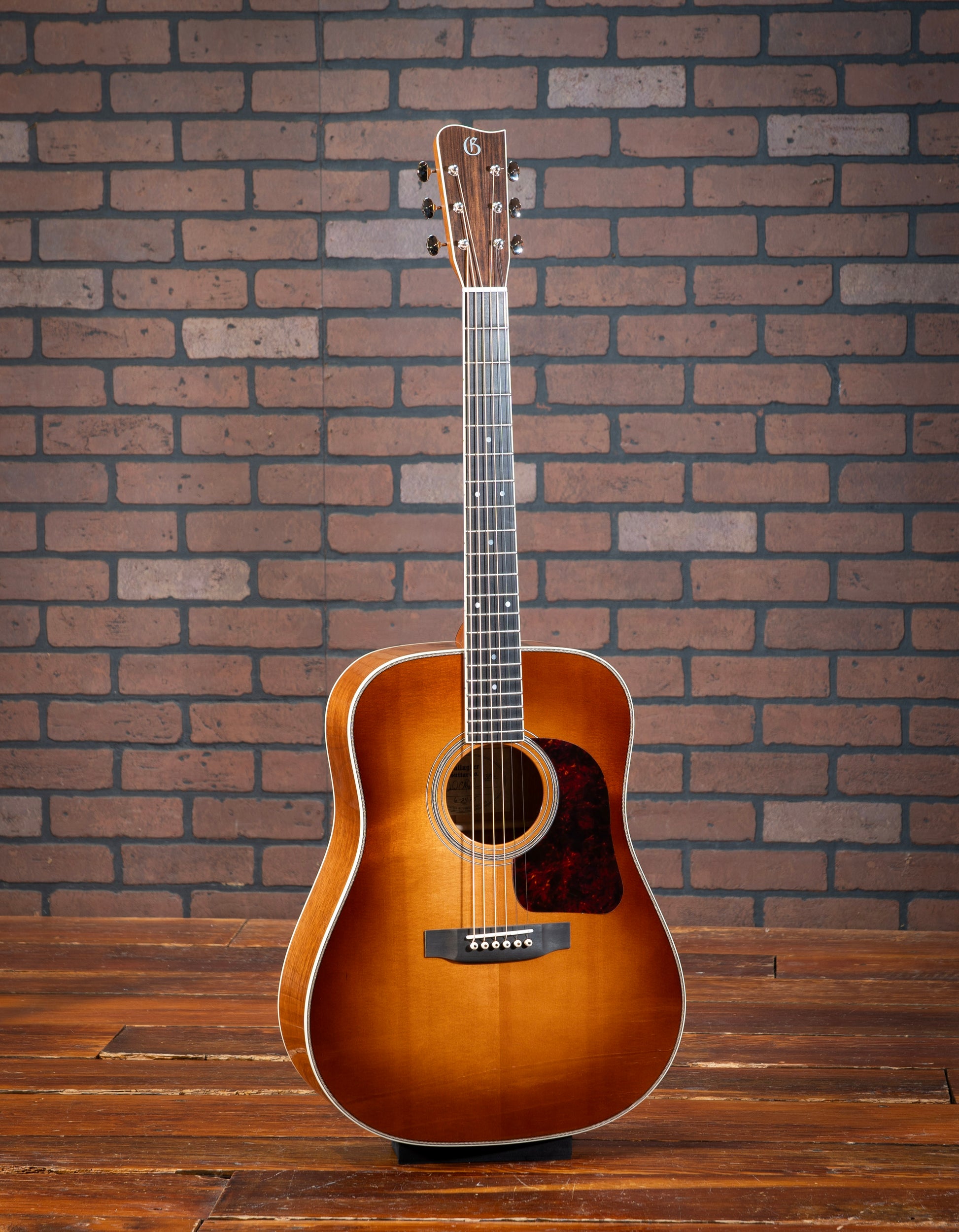 Gallagher Doc Watson Model acoustic guitar with Sitka spruce sunburst top, Mahogany sides, dreadnaught body, jumbo frets, and vintage aesthetic. 