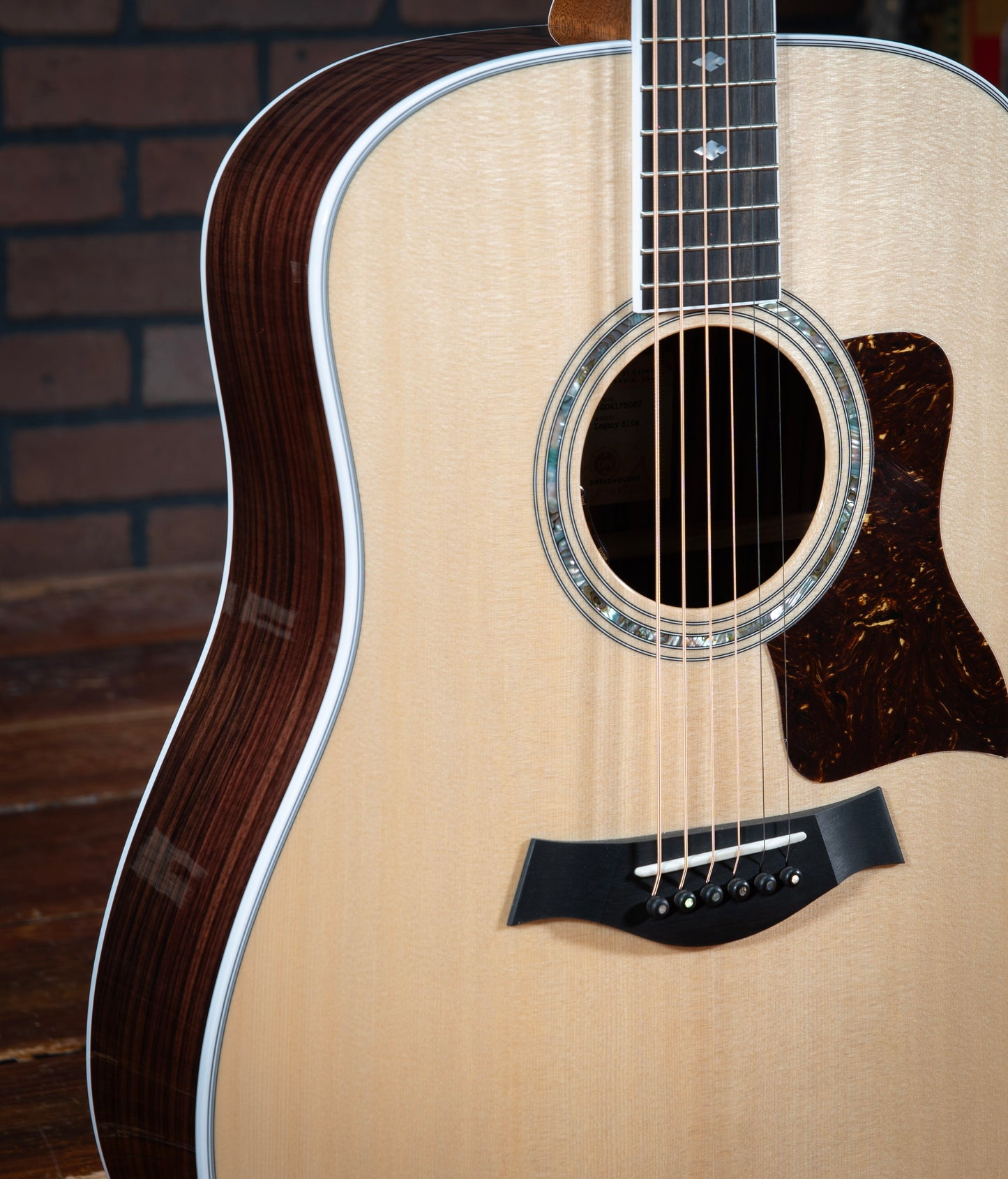 Taylor Legacy 810e acoustic electric guitar with spruce top, Indian rosewood sides, white binding, and three ring green abalone rosette