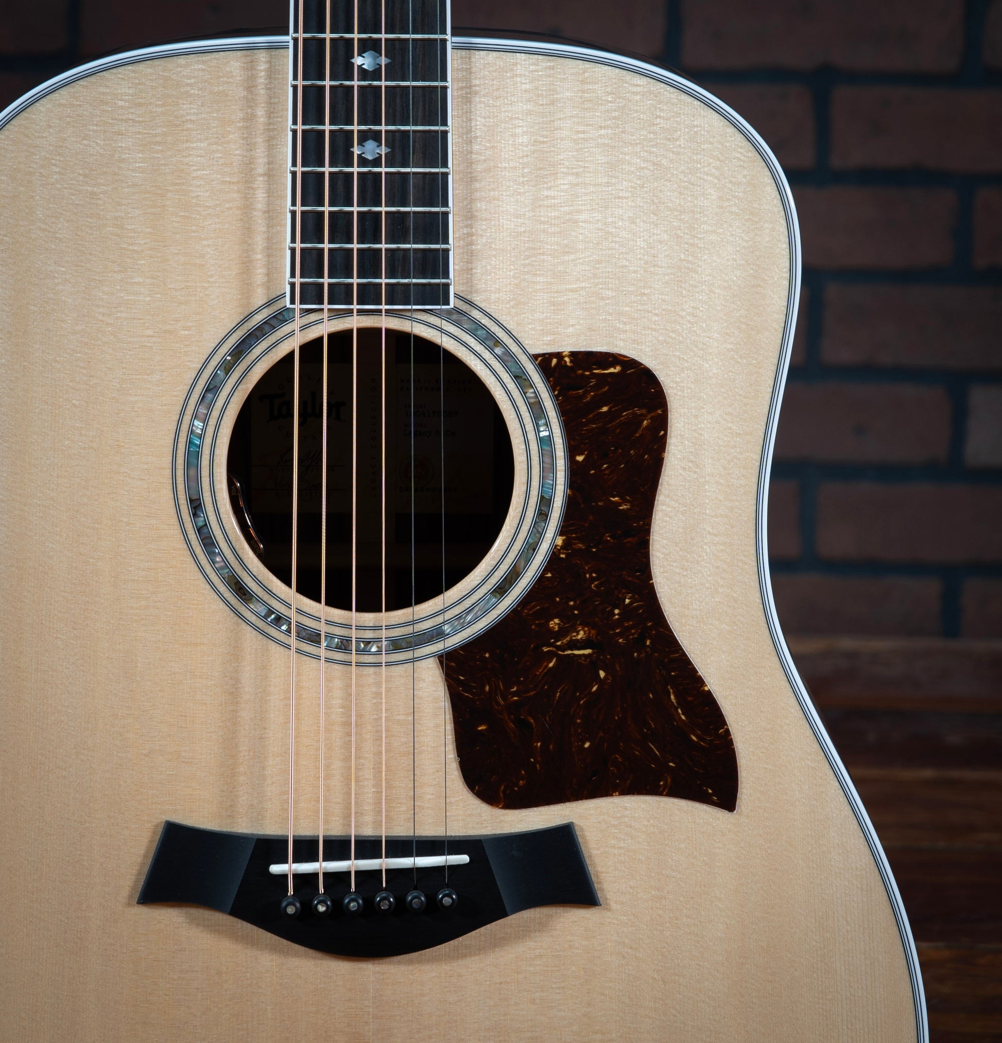 Taylor Legacy 810e acoustic electric guitar with faux tortoiseshell pickguard, 3 ring green abalone rosette, ebony bridge pins with green abalone dots, and mother-of-pearl diamond fretboard inlays